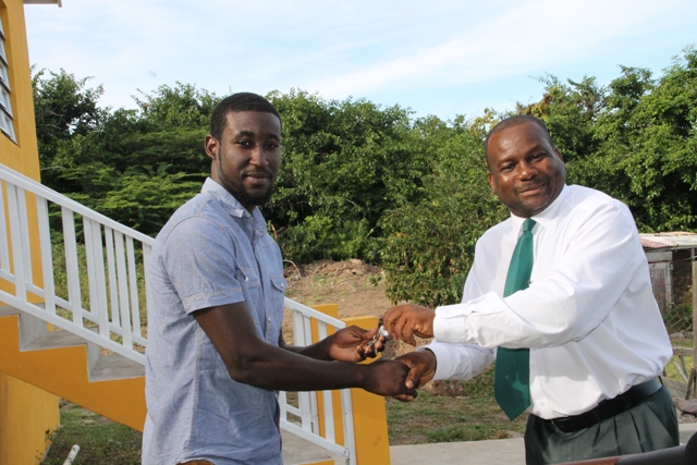 Adrian Williams receiving the keys to a two-bedroom furnished house, a gift from the Nevis Island Administration in collaboration with the Nevis Housing and Land Development Corporation, at the official Handing Over Ceremony at Eden Brown Estate on December 16, 2015